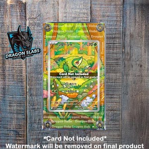 May include: A clear acrylic card holder with a Pokemon trading card inside. The card features a green and yellow illustrated character with Japanese text. The holder has the text "Dragon Slabs" and "Card Not Included".