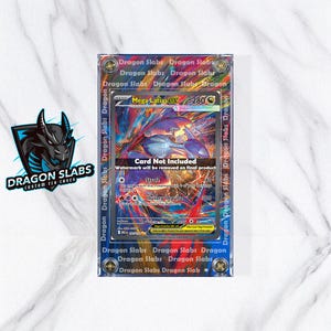 May include: A custom TCG case featuring a Mega Latias ex card. The card is displayed within a clear protective case with the text "Dragon Slabs" printed around the edges. The card is not included. The Dragon Slabs logo is visible in the corner.