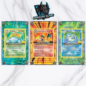 Può includere: Tre carte collezionabili Pokémon in custodie protettive trasparenti. Le carte presentano Venusaur, Charizard e Blastoise, ognuno con opere d'arte e statistiche uniche. Le custodie sono etichettate "Dragon Slabs" e hanno un bordo decorativo.