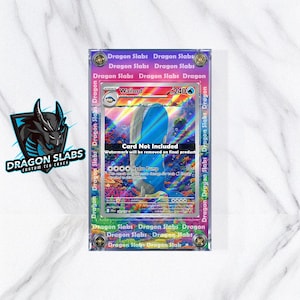May include: A framed trading card featuring a Wailord illustration with blue and white tones. The card is encased in a clear protective case with a purple and green border that reads "Dragon Slabs". The Dragon Slabs logo is visible.