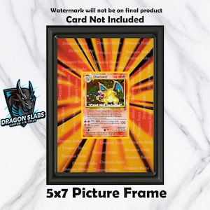 Puede incluir: Un marco de fotos negro de 5x7 pulgadas que muestra una carta coleccionable de Charizard. La tarjeta está centrada dentro de un fondo amarillo y naranja con el texto "Dragon Slabs" repetido. El marco tiene el texto "Card Not Included".