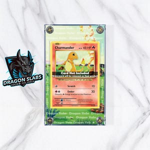 May include: A clear acrylic case with a Pokemon trading card inside. The card features a Charmander illustration with the text "Charmander" and "60 HP". The case has the text "Dragon Slabs" around the edges.