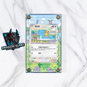 May include: A Pokémon trading card encased in a clear acrylic holder. The card features a blue creature with a yellow character on a colorful background. The holder is labeled "Dragon Slabs" and has text in Japanese.
