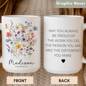 May include: A white ceramic mug featuring a colourful watercolour wildflower bouquet on the front with the name Madison and the title Pharmacist printed below. The back displays the text: May you always be proud of the work you do, the person you are, and the difference you make, followed by a small black heart.