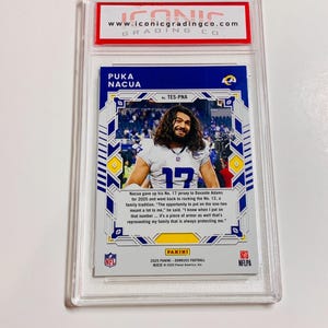 May include: A Puka Nacua football trading card, graded and encased in a protective holder. The card features a photo of the player in his jersey, with the number 12. The card is from the 2025 Panini Donruss Football series.