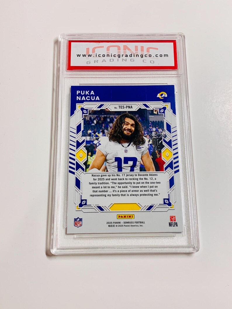 May include: A Puka Nacua football trading card, graded and encased in a protective holder. The card features a photo of the player in his jersey, with the number 12. The card is from the 2025 Panini Donruss Football series.