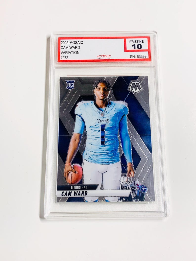 Puede incluir: Una tarjeta de f&uacute;tbol de Cam Ward del set 2025 Mosaic, calificada como Pristine 10. La tarjeta presenta a Cam Ward con un uniforme de los Titans azul claro, sosteniendo un bal&oacute;n de f&uacute;tbol. La tarjeta est&aacute; dentro de un protector transparente con el texto "2025 MOSAIC CAM WARD VARIATION #272".