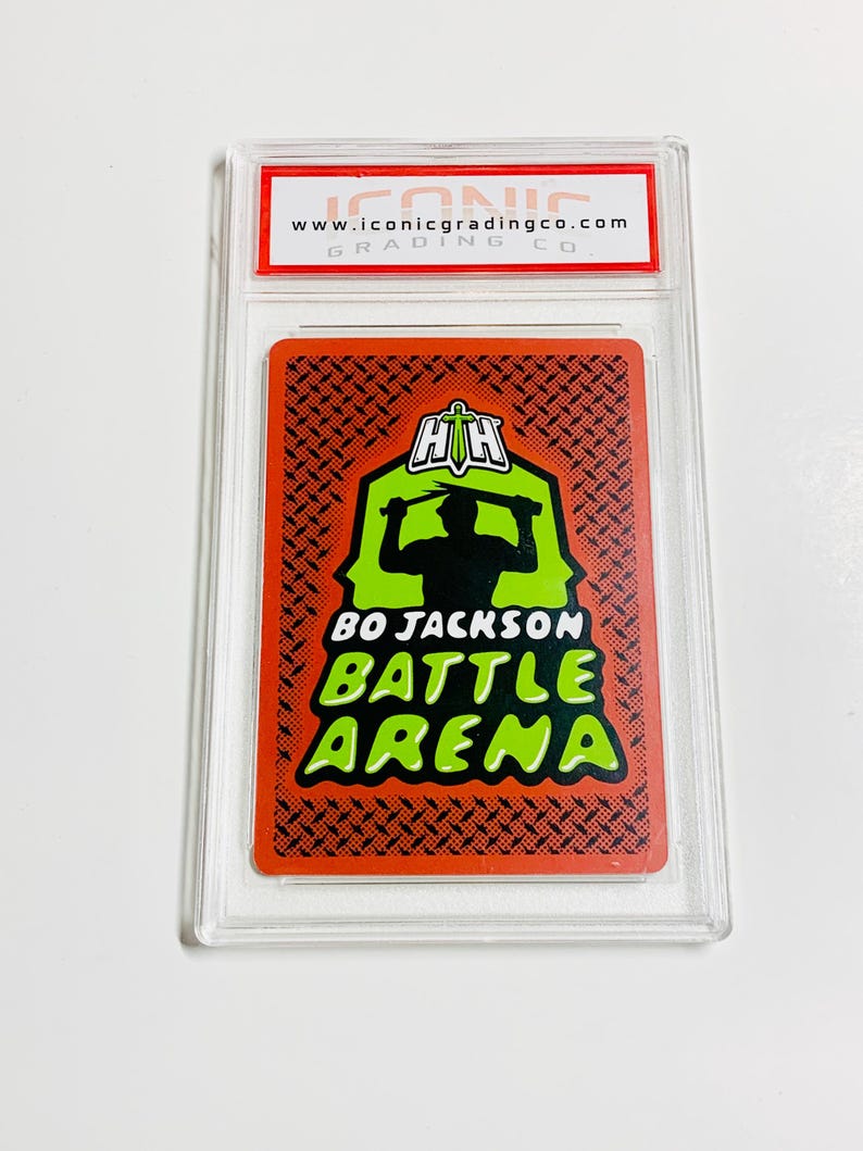 Peut inclure: Une carte &agrave; collectionner Bo Jackson Battle Arena dans un &eacute;tui de protection transparent. La carte pr&eacute;sente une silhouette d'une personne dans un design d'ar&egrave;ne vert et noir. Le texte "BO JACKSON BATTLE ARENA" est en vert et blanc. Le haut de l'&eacute;tui porte le texte "www.iconicgradingco.com".