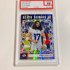 May include: A Puka Nacua Elite Series trading card from the 2025 Donruss set, graded Pristine 10. The card features a player in a white and blue uniform with the number 17. The card is encased in a clear protective holder.