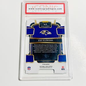 May include: A Zay Flowers football card from the 2023 Panini Select Football series. The card is graded by Iconic Grading Co. and features the Ravens' logo and player information. The card is encased in a protective holder.