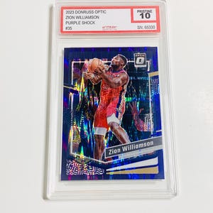 Pu&ograve; includere: Una carta collezionabile di basket con Zion Williamson in uniforme rossa e bianca, che tiene un pallone da basket. La carta &egrave; racchiusa in un supporto di plastica trasparente. Il testo sulla carta include "2023 Donruss Optic", "Purple Shock" e "Pristine 10."