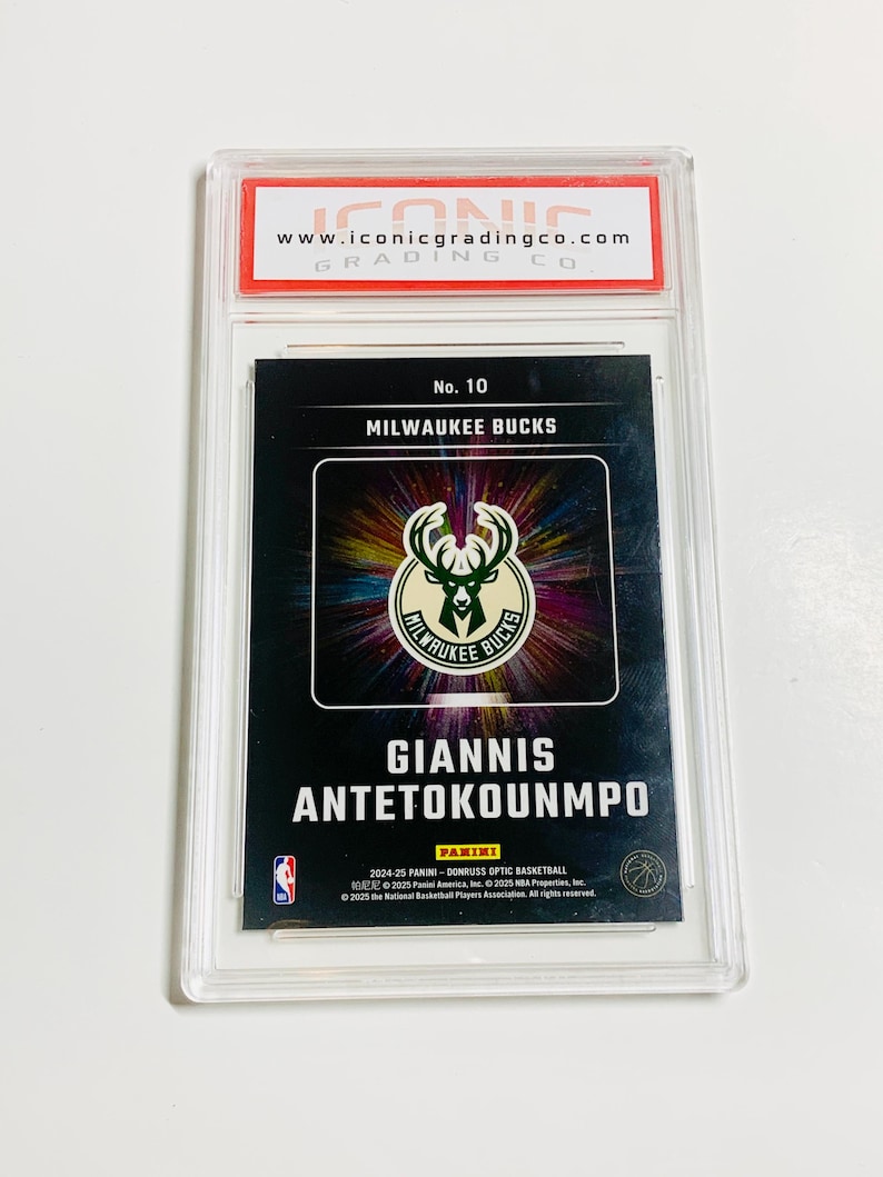 Pu&ograve; includere: Una carta collezionabile di basket di Giannis Antetokounmpo, valutata e racchiusa in un supporto di plastica trasparente. La carta presenta il logo dei Milwaukee Bucks e il nome "GIANNIS ANTETOKOUNMPO". Il logo e il sito web della societ&agrave; di valutazione sono visibili.