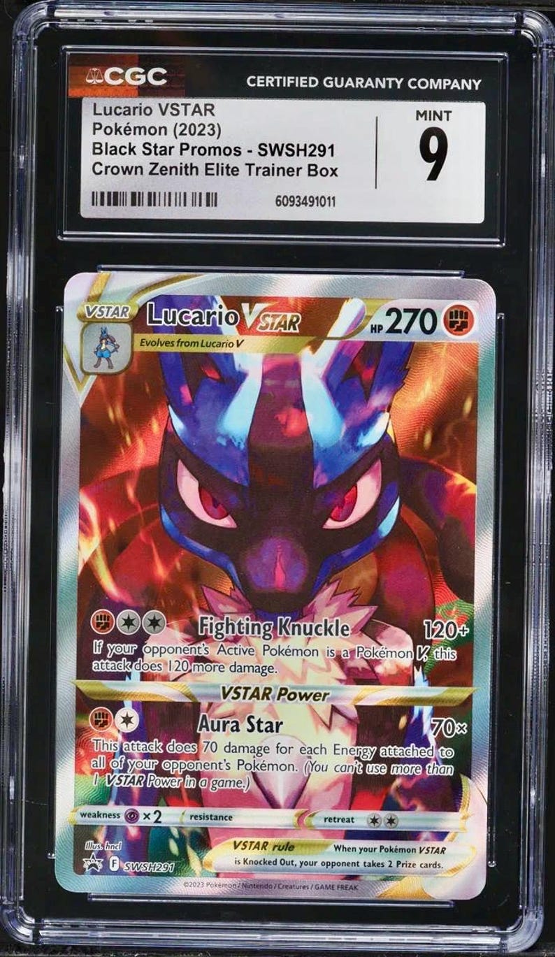 K&ouml;nnte beinhalten: Gradierte Lucario VSTAR Pok&eacute;mon-Karte aus der Crown Zenith Elite Trainer Box. Die Karte zeigt eine lebendige Illustration von Lucario in Blau-, Rot- und Goldt&ouml;nen. Die Karte ist von CGC mit Mint 9 bewertet.
