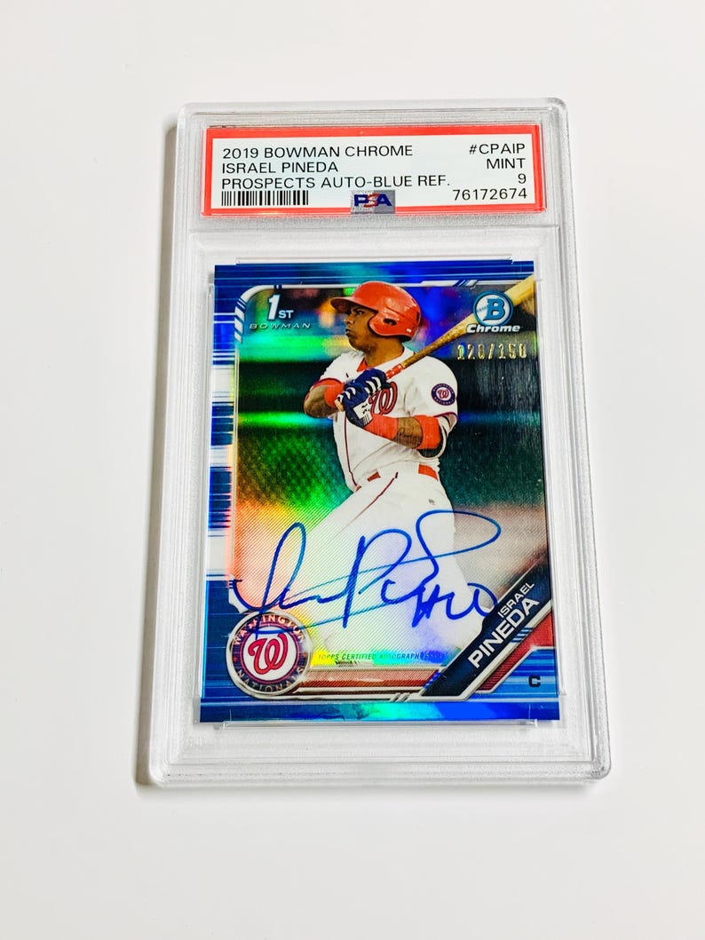 Op de afbeelding: Een honkbalkaart met Israel Pineda in een Washington Nationals-uniform. De kaart zit in een beschermende houder en heeft de tekst "2019 Bowman Chrome" en "Prospects Auto-Blue Ref.". De kaart is beoordeeld als Mint 9.