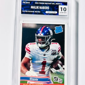 Könnte beinhalten: Eine bewertete Footballkarte mit Malik Nabers im Trikot der New York Giants. Die Karte trägt die Bezeichnung "Rated Rookie Retro" und enthält den Text "2024 Panini Instant NFL". Die Karte ist in einem Schutzhalter eingeschlossen und mit 10 bewertet.