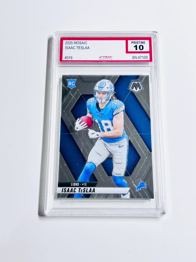 May include: A graded sports trading card featuring Isaac Teslaa of the Lions. The card has a mosaic design with blue and silver accents. The card is encased in a protective holder and is graded Pristine 10.