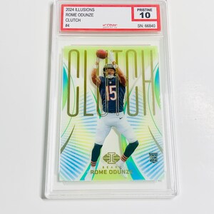 Puede incluir: Tarjeta coleccionable deportiva con Rome Odunze de los Chicago Bears. La tarjeta, calificada como Pristine 10, incluye "2024 Illusions", "Clutch" y "Rome Odunze". Est&aacute; protegida en un estuche.