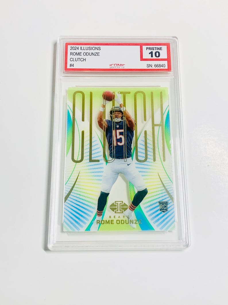 Puede incluir: Tarjeta coleccionable deportiva con Rome Odunze de los Chicago Bears. La tarjeta, calificada como Pristine 10, incluye "2024 Illusions", "Clutch" y "Rome Odunze". Est&aacute; protegida en un estuche.