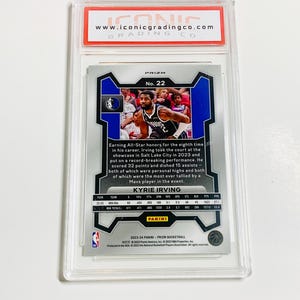 May include: A basketball trading card of Kyrie Irving, graded and encased in a protective holder. The card features a photo of Irving in action, with team and player statistics. The card is from the 2023-24 Panini Prizm Basketball series.