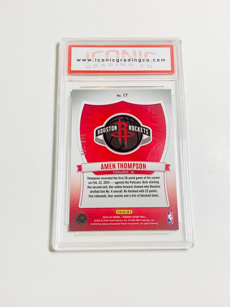 May include: A basketball trading card featuring Amen Thompson of the Houston Rockets, graded by Iconic Grading Co. The card has a red and white design with the Rockets logo and player information. The card is encased in a clear protective holder.