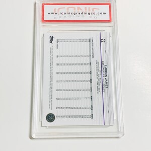 May include: A Topps LeBron James basketball card, graded and encased by Iconic Grading Co. The card features career stats and the player's information. The card is in a clear plastic case with a red and white label.