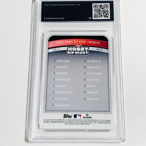 May include: A baseball card encased in a clear plastic holder. The card features a checklist of players, including Shohei Ohtani and Aaron Judge, with the text "TOPPS HOBBY RIP NIGHT CHECKLIST". The holder has a label from Advanced Grading.