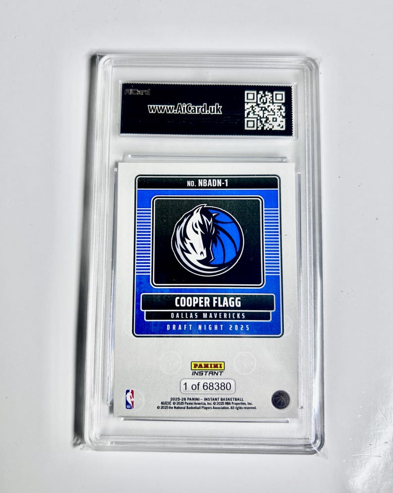 May include: A Cooper Flagg Dallas Mavericks Draft Night 2025 Panini Instant basketball card, encased in a protective holder. The card features a blue and white team logo and the text "www.AiCard.uk". The card is numbered 1 of 68380.