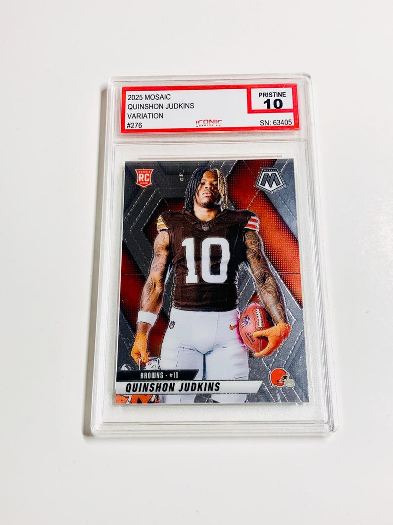 Pu&ograve; includere: Una carta collezionabile di football Quinshon Judkins 2025 Mosaic, variazione #276, valutata Pristine 10. La carta presenta un giocatore in uniforme dei Browns che tiene un pallone da football. La carta &egrave; racchiusa in un supporto protettivo trasparente.