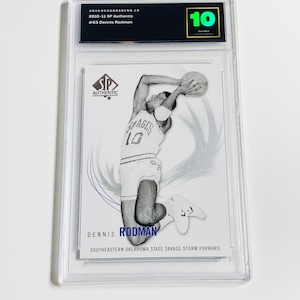 May include: A graded sports trading card featuring Dennis Rodman in action. The card is encased in a clear plastic holder and has a grade of 10. The card is from the 2010-11 SP Authentic series and features the text "SP Authentic".