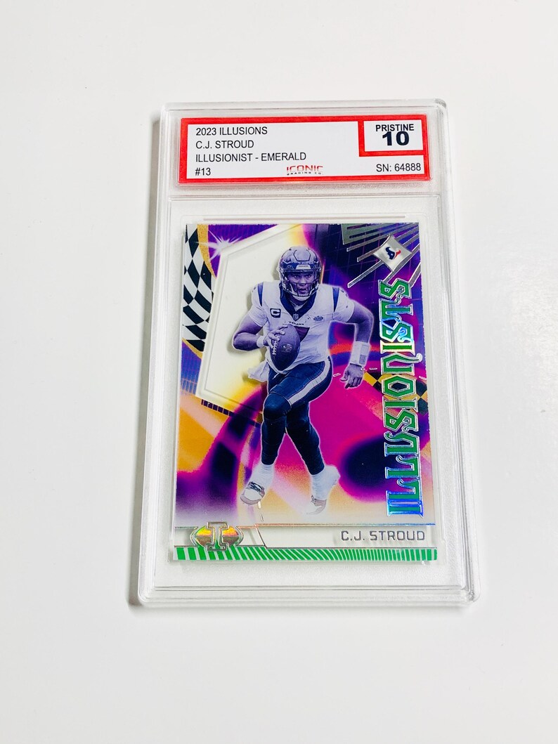 May include: A trading card featuring C.J. Stroud from the 2023 Illusions set, graded Pristine 10. The card has a vibrant design with the text "ILLUSIONISTS" and "C.J. STROUD". The card is encased in a protective holder.
