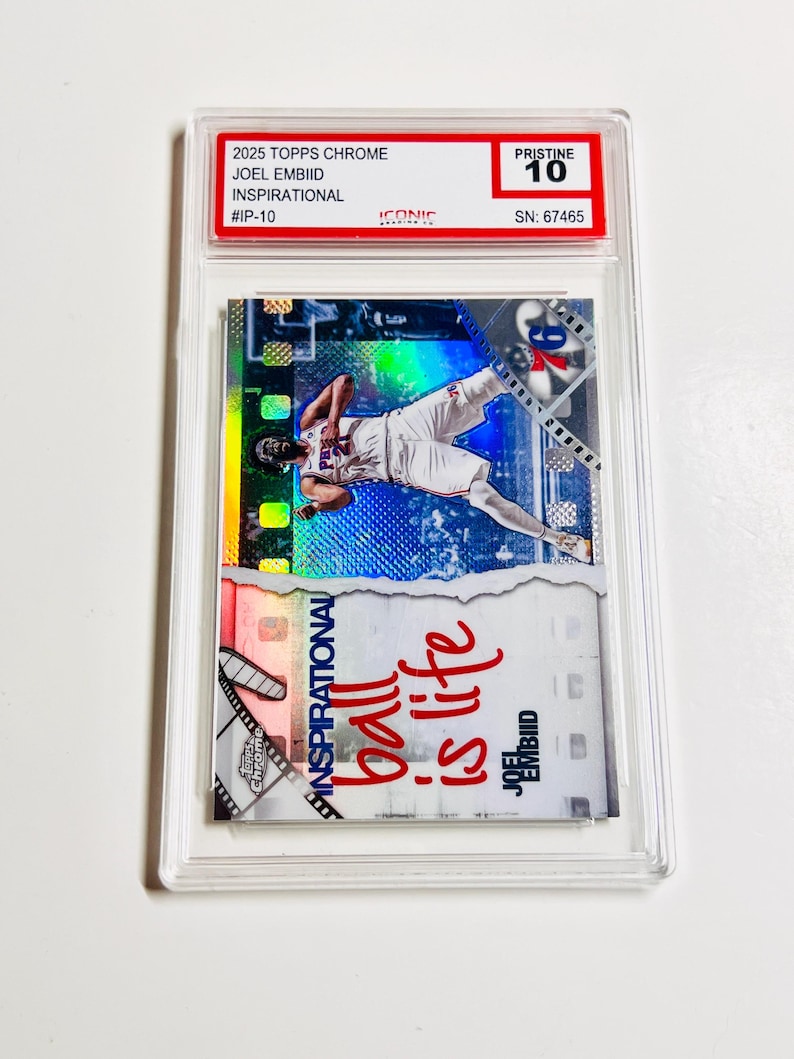 Puede incluir: Una tarjeta coleccionable Joel Embiid Inspirational 2025 Topps Chrome, calificada como Pristine 10, en un estuche protector. La tarjeta muestra a un jugador de baloncesto en acci&oacute;n, con el texto "ball is life".