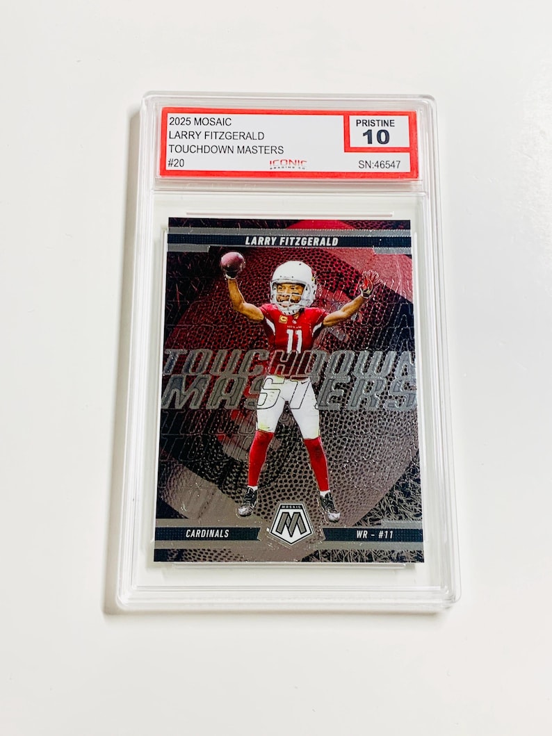 Puede incluir: Una tarjeta coleccionable 2025 Mosaic Larry Fitzgerald Touchdown Masters, calificada como Pristine 10, en una funda protectora. La tarjeta muestra a Fitzgerald con el uniforme rojo y blanco de los Cardinals, atrapando un bal&oacute;n.