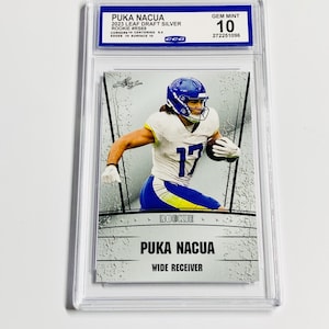 May include: A graded Puka Nacua rookie card. The card features a player in a blue and white uniform, with the number 17. The card is labeled "2023 Leaf Draft Silver" and is graded as "Gem Mint 10". The card is encased in a clear protective holder.