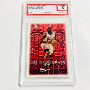 May include: A Michael Jordan trading card from the 1999 Upper Deck MVP series, graded Pristine 10. The card features Jordan in his Bulls uniform, with "mj exclusives" printed on the card. The card is encased in a protective holder.