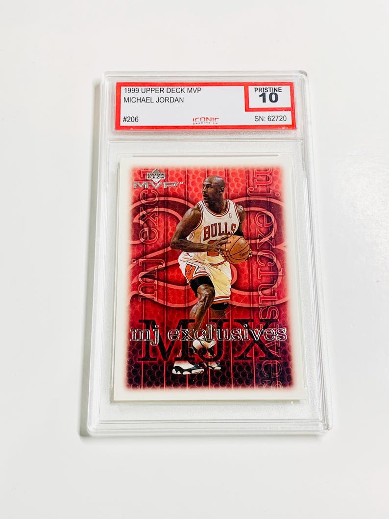 May include: A Michael Jordan trading card from the 1999 Upper Deck MVP series, graded Pristine 10. The card features Jordan in his Bulls uniform, with "mj exclusives" printed on the card. The card is encased in a protective holder.