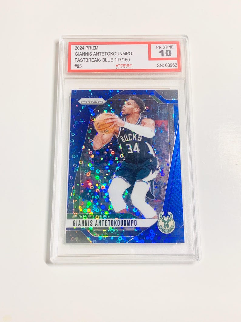 May include: A blue basketball card featuring Giannis Antetokounmpo in a Milwaukee Bucks uniform, holding a basketball. The card is graded Pristine 10 and is labeled as a 2024 Prizm Fastbreak Blue card.