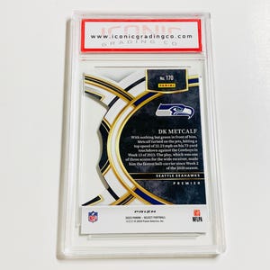 May include: A DK Metcalf football card from the Seattle Seahawks Premier series, graded by Iconic Grading Co. The card features a player image and details about a touchdown. The card is encased in a clear protective holder.