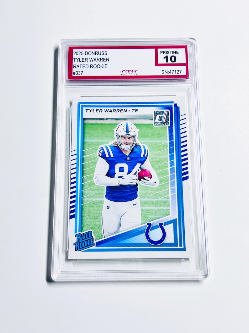 Puede incluir: Una tarjeta de f&uacute;tbol de Tyler Warren calificada del conjunto Donruss 2025. La tarjeta presenta a Warren con su uniforme de los Colts de Indian&aacute;polis, sosteniendo un bal&oacute;n de f&uacute;tbol. La tarjeta est&aacute; etiquetada como "Rated Rookie" y est&aacute; calificada como "Pristine 10".