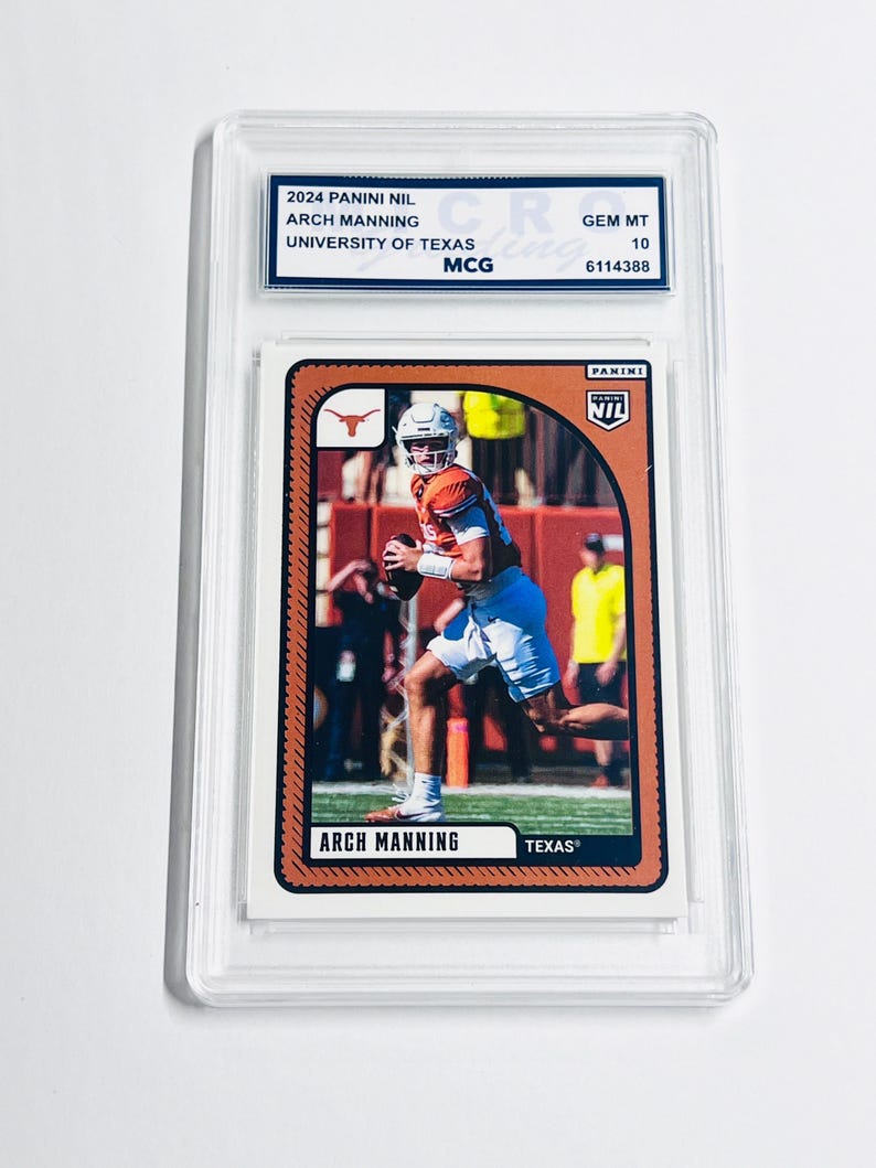 K&ouml;nnte beinhalten: Eine 2024 Panini NIL Arch Manning University of Texas Sammelkarte in einer durchsichtigen Kunststoffh&uuml;lle. Die Karte zeigt ein Foto eines Footballspielers in einem orangefarbenen Trikot und wei&szlig;en Shorts, mit dem aufgedruckten Text Arch Manning und Texas.