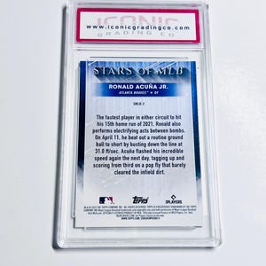 May include: A baseball card featuring Ronald Acu&ntilde;a Jr. of the Atlanta Braves, graded by Iconic Grading Co. The card is encased in a clear protective holder. The card's design includes the text "STARS OF MLB".