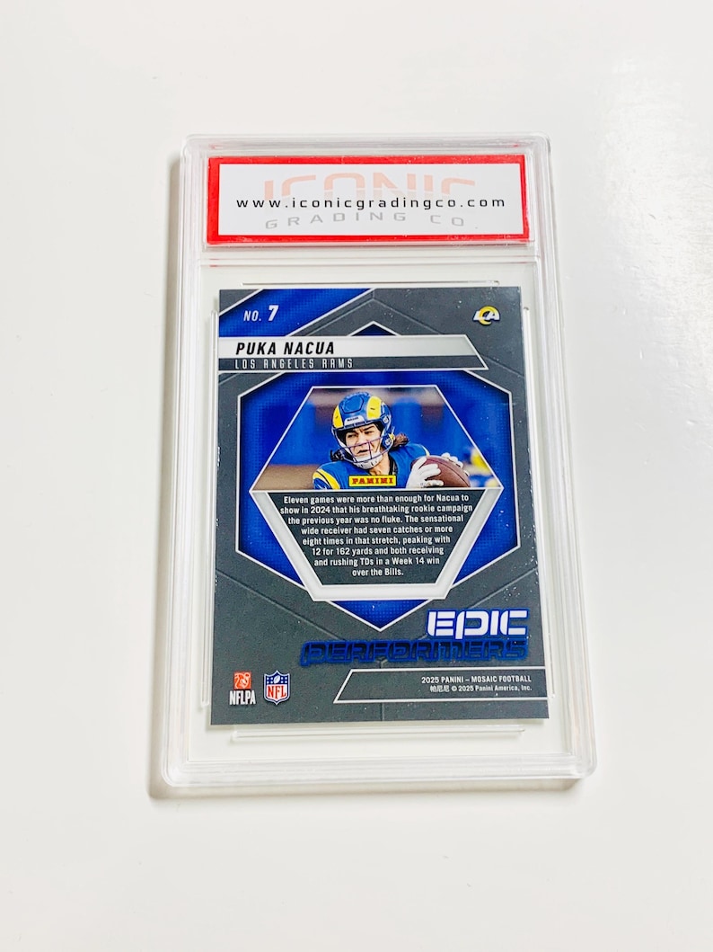 May include: A Puka Nacua Los Angeles Rams football card, graded and encased in a protective holder. The card features a photo of the player in action, with the Panini logo and the text "EPIC PERFORMERS". The card is from the 2025 Panini Mosaic Football collection.