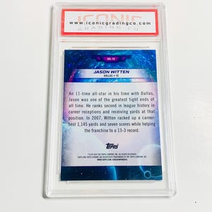 May include: A graded Jason Witten football card in a clear protective case. The card features a blue and purple background with the player's name and team. The top of the case has a red and white label with the Iconic Grading Co. logo.