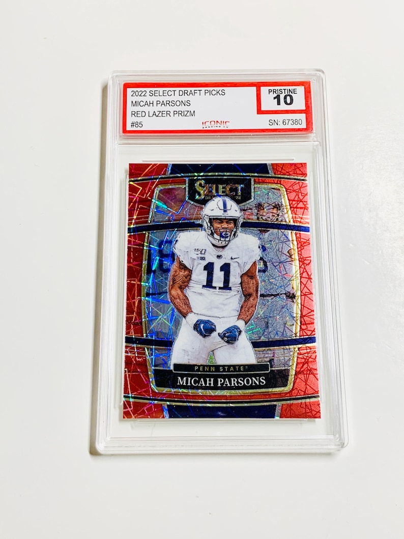 May include: A football trading card featuring Micah Parsons in a Penn State uniform. The card is a Red Lazer Prizm from the 2022 Select Draft Picks series, graded Pristine 10. The card is encased in a clear protective holder.