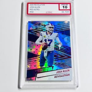 May include: A graded Josh Allen football card from the 2025 Revolution series. The card features a player image with a blue and silver holographic design. The card is graded Pristine 10, with the text "JOSH ALLEN" and "REVOLUTION".