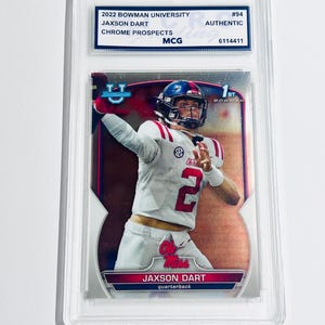 K&ouml;nnte beinhalten: Eine 2022 Bowman University Chrome Prospects Sammelkarte von Jaxson Dart, von MCG als authentisch bewertet. Die Karte zeigt den Athleten in einem wei&szlig;en Ole Miss Trikot mit der Nummer 2, eingeschlossen in einer transparenten Kunststoffh&uuml;lle.