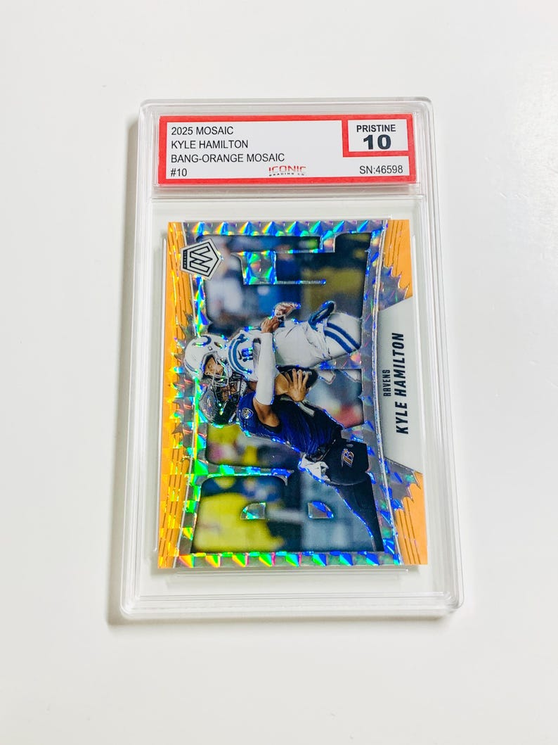 May include: A football trading card featuring Kyle Hamilton in a mosaic design. The card is graded Pristine 10 and includes the text "2025 MOSAIC KYLE HAMILTON BANG-ORANGE MOSAIC #10". The card is encased in a clear protective holder.