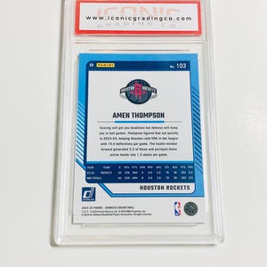 Op de afbeelding: Een basketbal trading card van Amen Thompson van de Houston Rockets, in een beschermende houder. De kaart toont spelersstatistieken, teamlogo en het Panini Donruss logo. Beoordeeld door Iconic Grading Co.