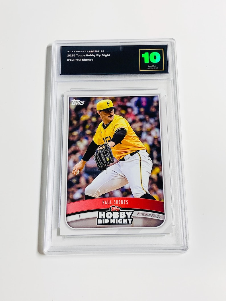 May include: A graded baseball card featuring Paul Skenes in a yellow and black Pittsburgh Pirates uniform. The card is encased in a clear plastic holder with a grade of 10. The card's text includes "2025 Topps Hobby Rip Night" and "Pittsburgh Pirates."