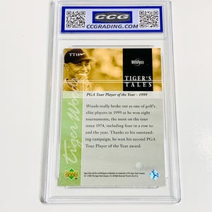 Pu&ograve; includere: Una carta collezionabile racchiusa in un supporto protettivo trasparente. La carta presenta un'immagine di Tiger Woods e il testo "TIGER'S TALES" e "PGA Tour Player of the Year - 1999". La carta &egrave; valutata da CCG.