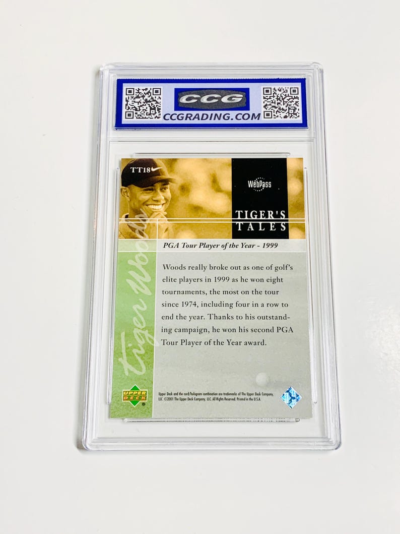 Pu&ograve; includere: Una carta collezionabile racchiusa in un supporto protettivo trasparente. La carta presenta un'immagine di Tiger Woods e il testo "TIGER'S TALES" e "PGA Tour Player of the Year - 1999". La carta &egrave; valutata da CCG.